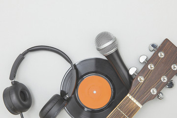 Musical equipment backgound with headphones, vinyl record, microphone and guitar