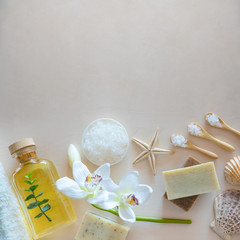 Top view of Wellness setting. Sea salt, soap, towel, olive oil and flowers on wooden background and Space for copy