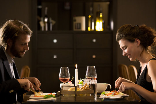 Man and woman eating during candlelight lunch.Couple in love romantic dinner at restaurant