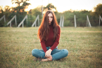 Pretty young woman sits on old stadium