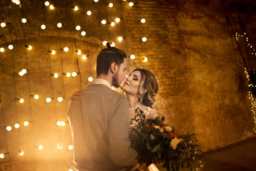 Stylish groom and brise on the vintage loft lamps background