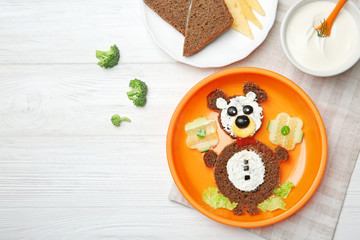 Funny food idea for kid breakfast on wooden background