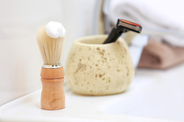 Fototapeta na wymiar Shaving brush for man with foam on sink