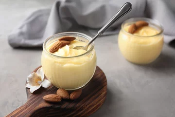Gardinen Glass jar with vanilla pudding with almond on table © Africa Studio