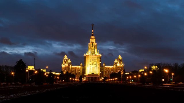 Moscow, Russia. Time-lapse of illuminated Lomonosov Moscow State University at night. Popular landmark in Russia. Time-lapse with car trails and dark fast pacing sunset sky. Zoom in