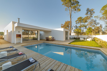 Modern house with garden swimming pool and wooden deck