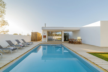 Modern house with garden swimming pool and wooden deck