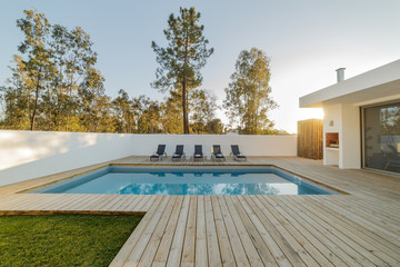 Modern house with garden swimming pool and wooden deck - obrazy, fototapety, plakaty