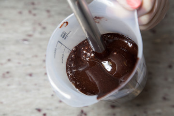 whipping chocolate glaze in a white grain glass