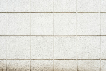 Deep texture of a white painted porous stone on the facade of the building. Finishing the facade of the building into square sections. Texture background with stone wall