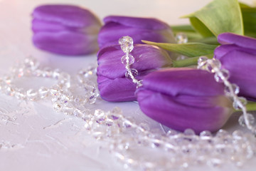Fototapeta na wymiar purple pink tulips glass beads on the table, the spring of love the beauty of concrete background