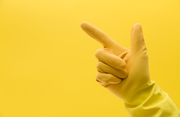 Pointing hand gesture made by a hand in a yellow rubber cleaning glove