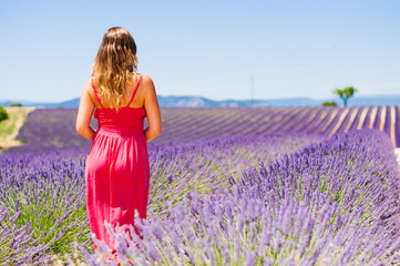 Woman in long fuchsia dress enjoying the view of lavender field