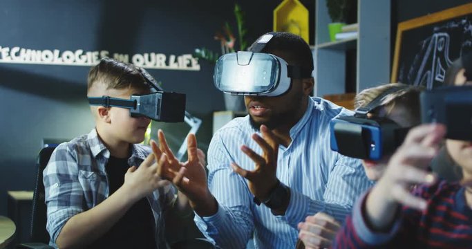 Group of kids and teacher sitting in contemporary laboratory and studying 3d designing and modeling. Movement 4K shot on Red cinema camera.