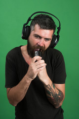Singer with beard and surprised face listens to music.