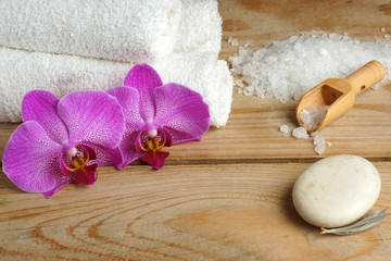 Orchid flowers on a wooden background with white sea salt