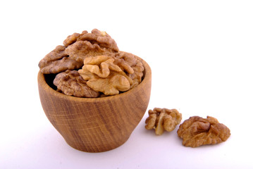 Walnut in a wooden bowl on a white background.