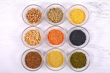 Assorted healthy organic cereals on white wooden background.