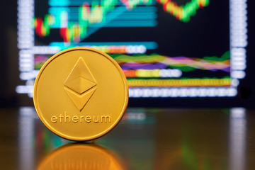 Gold coin ethereum stacked on a bright background of business graphics close-up. Crypto-currency ETH. Anonymous. Virtual currency                                                       