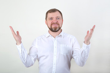 A bearded man in a white shirt raised his hands up. Shows a gesture.