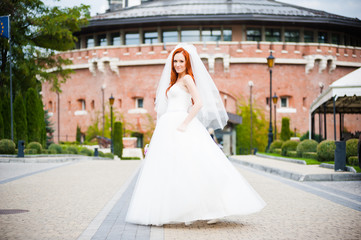 Obraz premium Fashion bride girl in gorgeous wedding dress with wedding bouquet of flowers