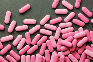 Pink medicine pills on a grey background