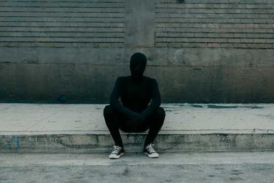Invisible man sitting on curb