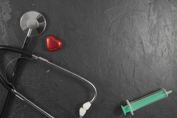 Ein Stethoskop als Freisteller isoliert auf einer grauen Schiefertafel.