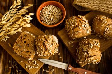 Buns with sunflower seeds on the wooden cutting board.Top view.
