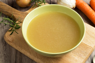 Chicken bone broth in a green soup bowl
