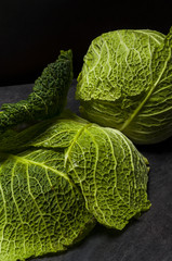 Moody low light picture of fresh cabbage at stone black table