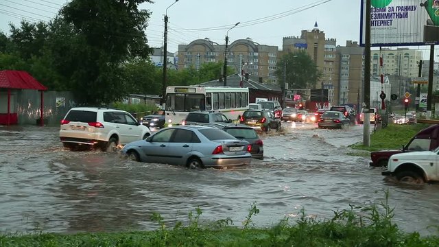people and cars on the flooded streets after a heavy rain