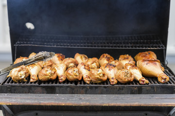 Appetizing turkey drumsticks on the grill, on charcoal stove with fire and smoke close-up . Concept summer picnic, nutrition, diet