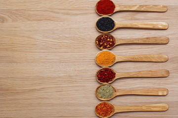 Spice. Spice in a wooden spoon. Herbs. Curry, saffron, turmeric, pepper and others on a wooden background.