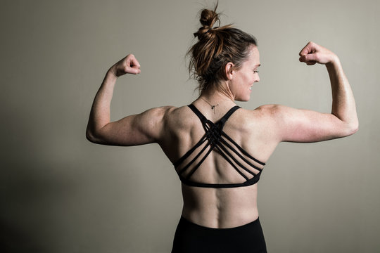 Woman flexing her muscles in the home gym