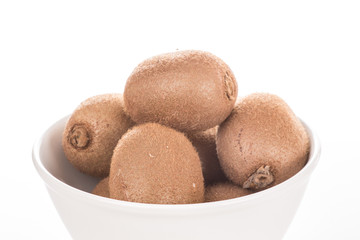 Schüssel mit Kiwis vor weißem Hintergrund