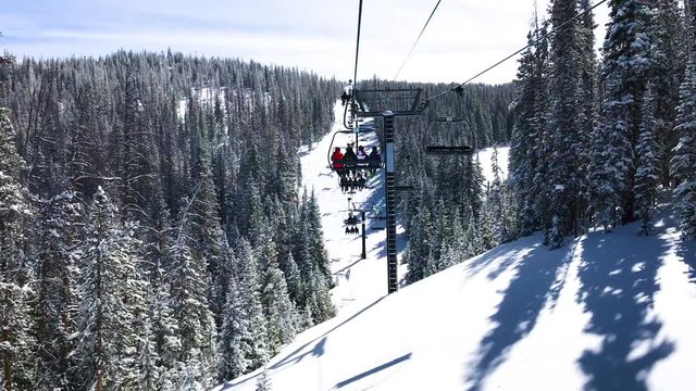 Riding a ski lift through snow covered trees