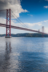 Obraz premium LISBON, PORTUGAL - January 28, 2011: walks along the banks of Tagus River in Belem and famouse bridge of 25th April over river on January 28, 2011, Lisbon, Portugal