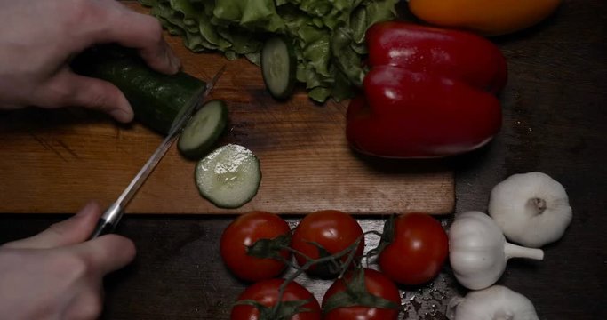 Kitchen table with vegetables, cucumber, red, yellow pepper, tomato, green salad, champignons, garlic knife....