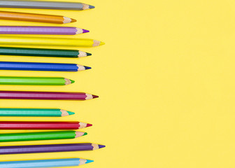 Color pencils for drawing on a yellow background. Background.