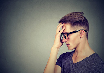 casual stressed man in glasses looking down