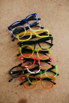 Collection of different colorful eyeglasses frames on a wooden table
