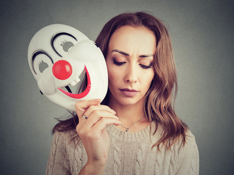 Sad woman with clown mask