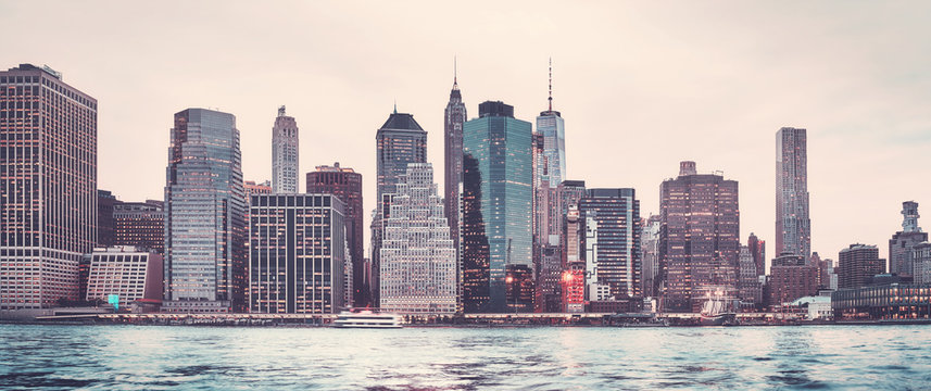 Retro stylized panoramic picture of the Manhattan skyline at sunset, New York City, USA.