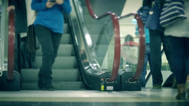 Unrecognizable people on moving staircase of a metro station, slow motion shot