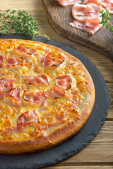 pizza with ham on wooden background