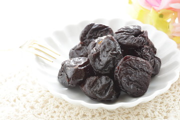 Dried fruit, prune on white dish with copy space for healthy food image