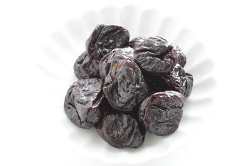 Dried fruit, prune on white dish with copy space for healthy food image