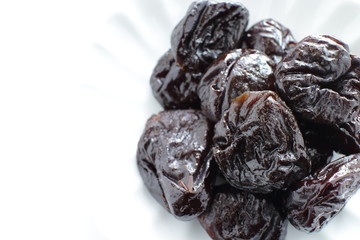 Dried fruit, prune on white dish with copy space for healthy food image