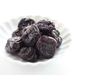 Dried fruit, prune on white dish with copy space for healthy food image
